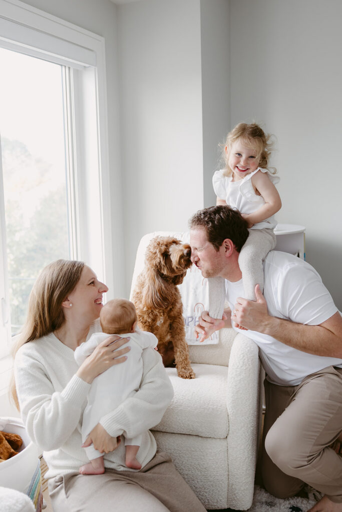 Poodle kissing dad in a family photo.