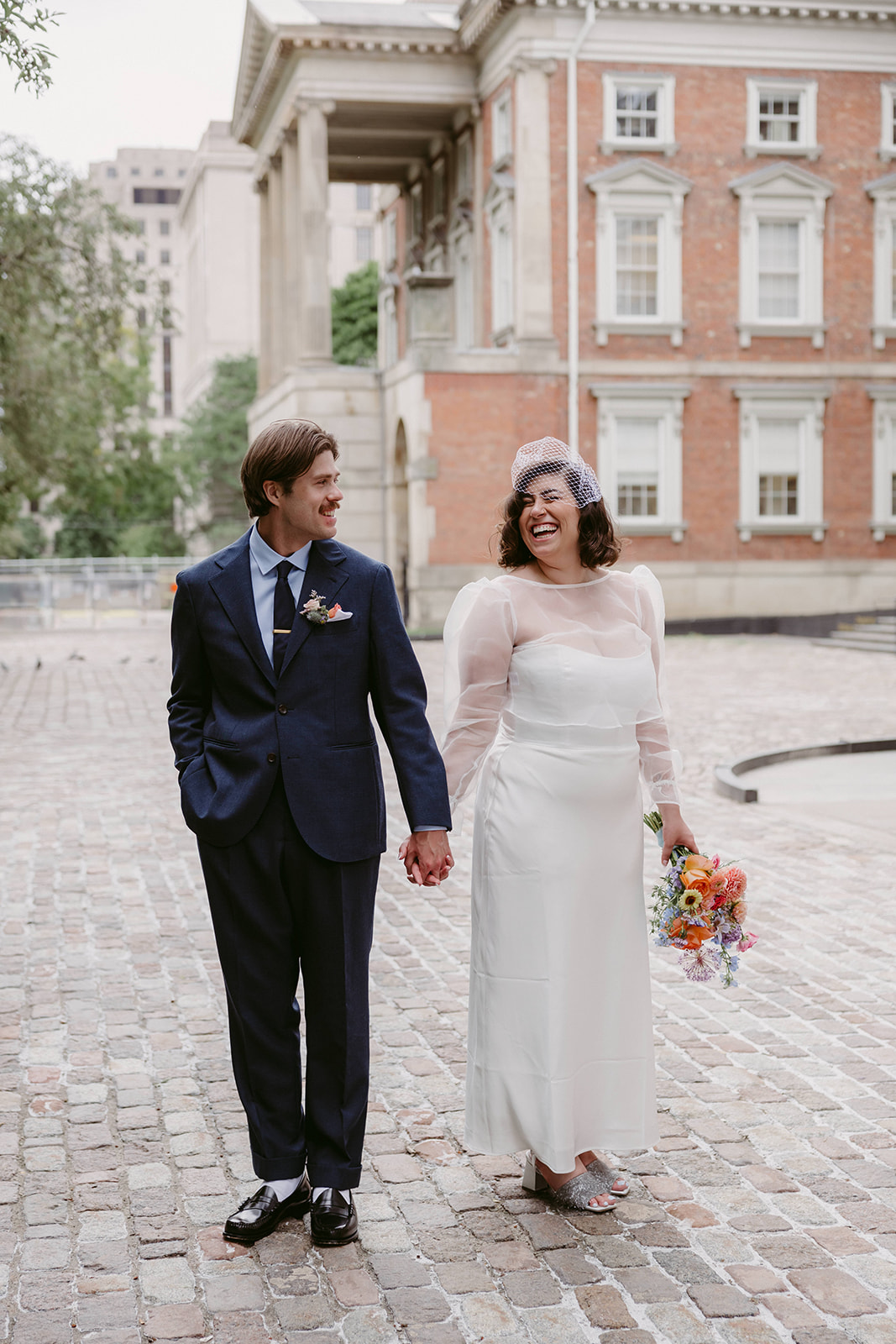 Bride and groom exchanging vows inside Toronto City Hall with a small group of family and friends.